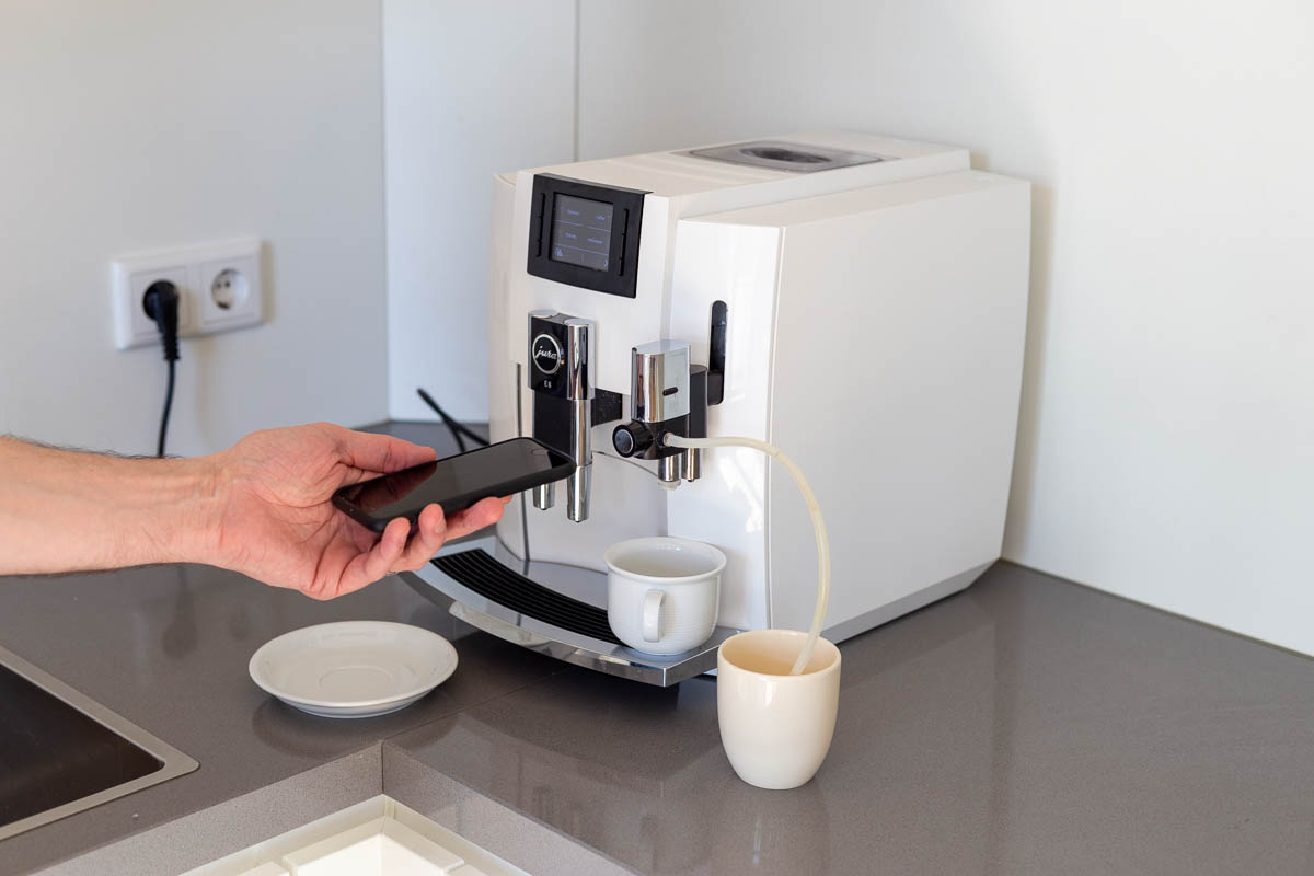 Touchpoint: Kaffeevollautomat – Eine Service-Mitarbeiterin hört über das Smartphone die Arbeitsgeräusche des Kaffevollautomaten