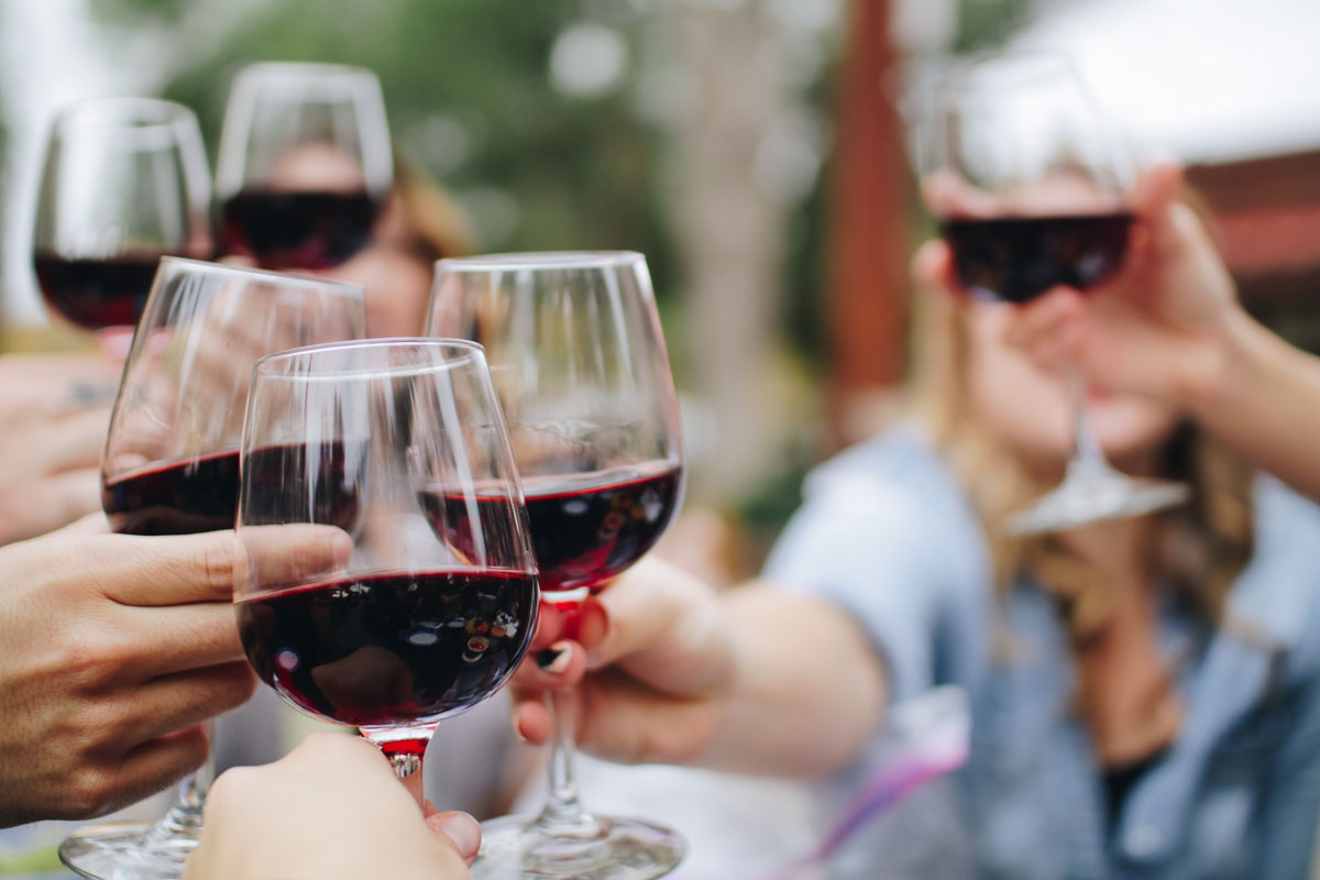 Touchpoint: Bei einer Weinprobe stoßen Menschen mit Weingläsern an.