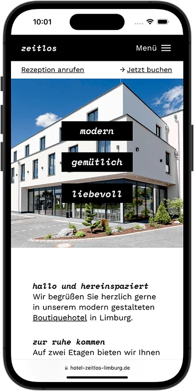 Smartphone-Bildschirm zeigt Webseite eines modernen, weißen Gebäudes mit Texten zu einem Boutiquehotel in Limburg.
